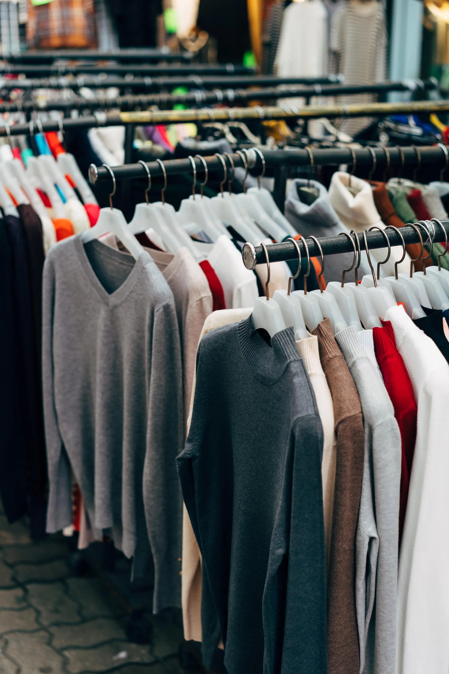 Row of clothing on hangers at a market or store.