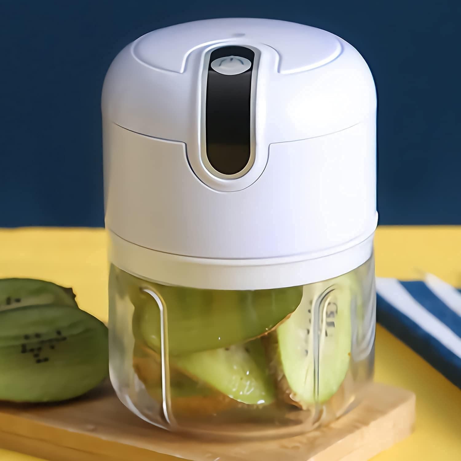 Small food processor with sliced kiwis on a wooden board