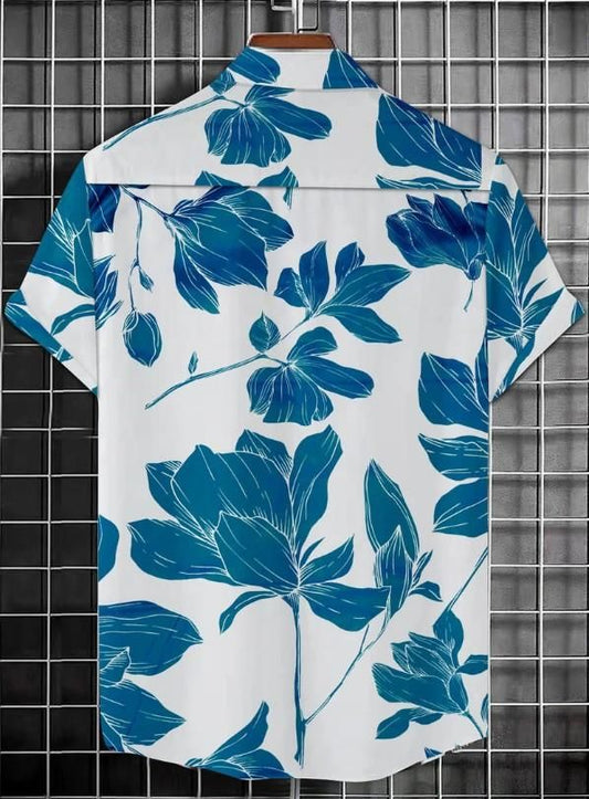 White shirt with blue floral pattern on a hanger against a tiled wall.