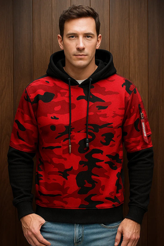 Man wearing a red camouflage hoodie against a wooden background